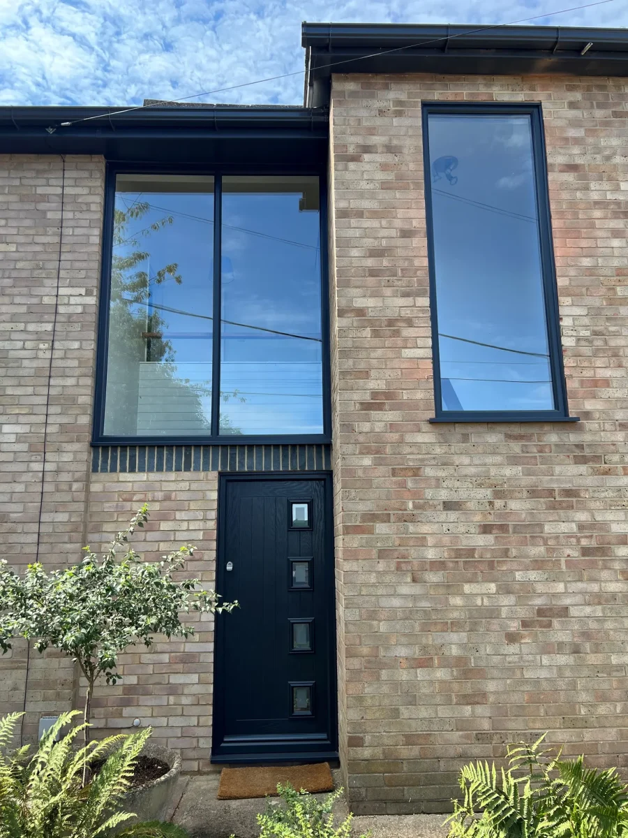 black casement windows in modern brick house with black composite door