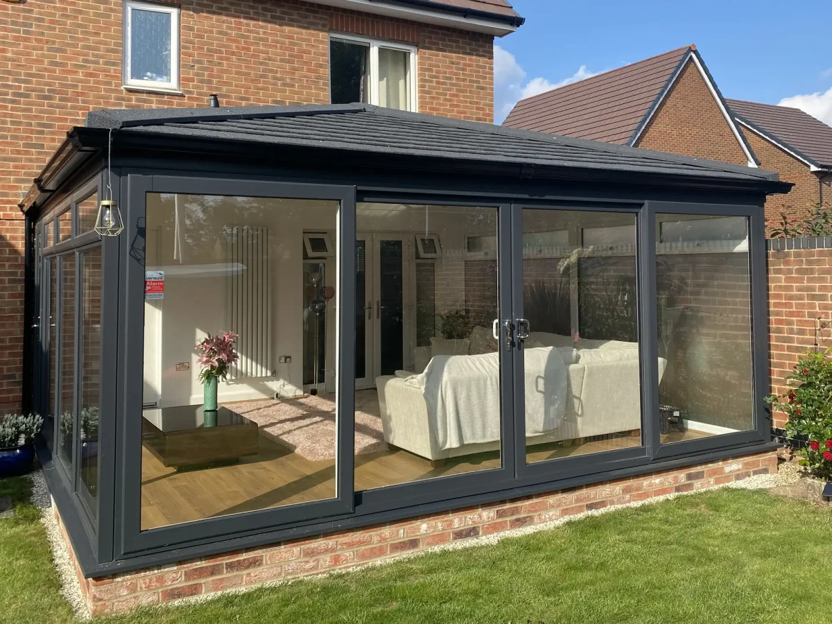 Edwardian amazon solid roof with charcoal tapco tiles and patio doors