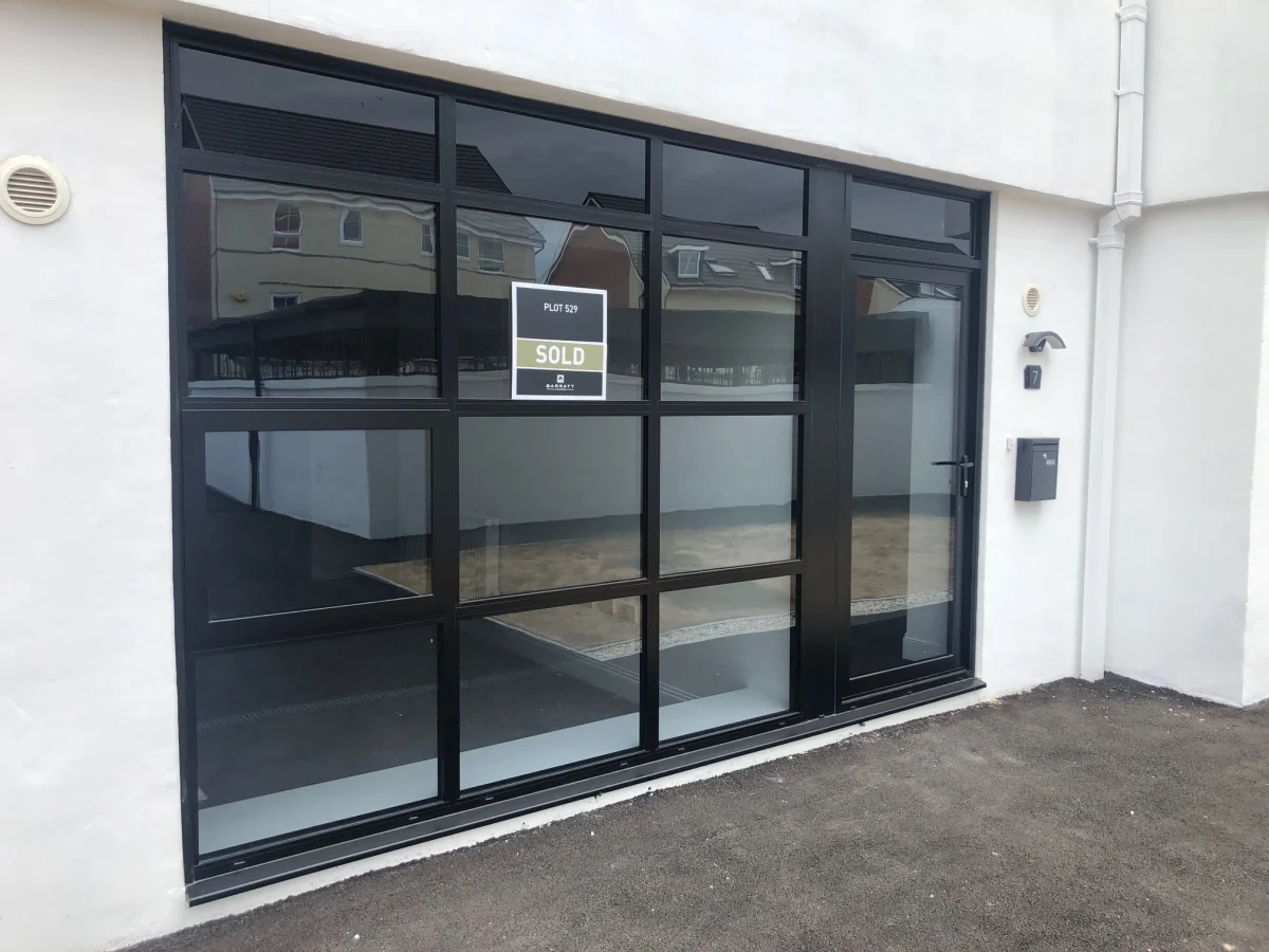 black aluminium single door in large black window